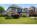 Elegant two-story home with a well-maintained lawn, two-car garage, and decorative shrubs at 341 Declaire Ne Way, Marietta, GA 30067