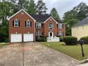 Inviting two-story brick home with well-maintained lawn, two-car garage, and traditional architectural details at 787 Wynbrooke Pkwy, Stone Mountain, GA 30087