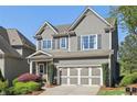 Attractive two-story home featuring a gray exterior, complementary shutters, and a well-maintained front yard at 8385 E Village School E Dr, Cumming, GA 30041