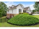 Side view of the home showing the manicured landscaping, brick foundation, and white siding at 1127 Bank Se St, Smyrna, GA 30080