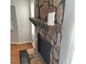 Close-up of the stone fireplace with a wooden mantle and a black firebox at 4149 Silver Hill Ct, Snellville, GA 30039