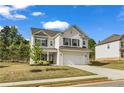Charming two-story home with a brick facade, black shutters, attached two car garage and well maintained lawn at 5140 Woodline View Cir, Auburn, GA 30011