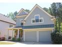 Charming two-story home with a covered front porch, stone accents, and a two-car garage at 307 Downing Creek Trl, Canton, GA 30114