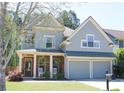 Charming two-story home with a covered front porch, stone accents, and a two-car garage at 307 Downing Creek Trl, Canton, GA 30114