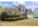 Charming two-story home with a manicured lawn and a two-car garage and stone detailing at 902 Brumley Nw Ln, Kennesaw, GA 30152