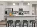 Modern kitchen with white cabinets, stainless steel appliances, and a granite countertop island with seating at 4470 Madison Hall Dr, Cumming, GA 30028