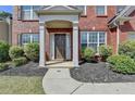 Inviting front entrance with a covered porch, lush landscaping, and a brick facade at 580 Hammersmith Dr, Suwanee, GA 30024