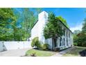 White two-story home with black shutters, lush landscaping, and a driveway leading to the house at 909 Otter Ne Way, Marietta, GA 30068