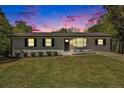 Charming single-story home boasts a well-manicured lawn and fresh exterior paint at twilight at 2804 Carolyn Se Dr, Smyrna, GA 30080