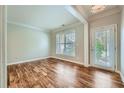 Bright living room featuring hardwood floors, neutral walls, a large window, and a glass panel door leading to the outside at 3765 Clear Lake Nw Way, Acworth, GA 30101