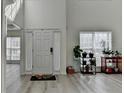 Bright foyer featuring soaring ceilings, light wood-look flooring and natural light at 2822 Savannah Walk Cv, Suwanee, GA 30024