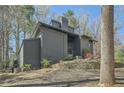 View of the back of the property, showcasing its unique architectural style and mature trees at 3011 Cravey Trl, Tucker, GA 30345