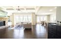 Open-concept living room featuring a stone fireplace, coffered ceilings, and large windows for natural light at 715 Laura Jean Court, Buford, GA 30518