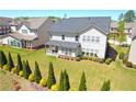 Spacious backyard featuring a well-kept lawn, lush landscaping, and a covered patio at 715 Laura Jean Ct, Buford, GA 30518