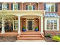 Inviting front porch with brick steps, columns, and decorative plants, creating a welcoming entrance at 325 N Saint Phillip Ln, Alpharetta, GA 30022