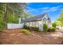 A fenced backyard with a pathway leading to the home, surrounded by pine straw and trees at 1164 Britley Park Ln, Woodstock, GA 30189