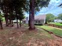 Landscaped backyard with mature trees and a brick retaining wall at 1552 Longwood Dr, Lawrenceville, GA 30043