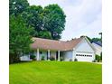 Charming home with a well-maintained lawn, flower beds, and a two-car garage at 1552 Longwood Dr, Lawrenceville, GA 30043