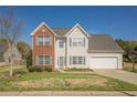 Inviting two-story home with a brick accent, a well-maintained lawn, and an attached garage at 2470 Cordillo Dr, Dacula, GA 30019
