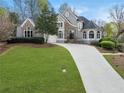 Beautiful gray stucco and stone home with a well-kept lawn and a long concrete driveway at 315 Stanyan Pl, Alpharetta, GA 30022