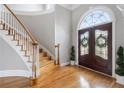 Elegant foyer with hardwood floors, curved staircase, and a decorative glass double-door entrance at 315 Stanyan Pl, Alpharetta, GA 30022