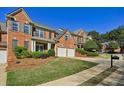 Traditional brick home showcases lush landscaping, a two-car garage and a well-kept lawn on a sunny day at 132 Westchester Se Dr, Smyrna, GA 30082