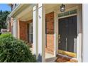 Close-up of a classic front door with white trim, a small porch, and lush green landscaping at 132 Westchester Se Dr, Smyrna, GA 30082