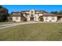 Expansive luxury home with a circular driveway and well manicured lawn at 150 White Tail Ct, Fayetteville, GA 30214