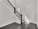 Elegant entryway features a staircase with black iron railings and hardwood floors at 399 Tillman Pass, Woodstock, GA 30188