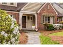 Close-up of the front porch featuring a stone path, wood door, and flowering shrubs at 883 Wildwood Ne Rd, Atlanta, GA 30324