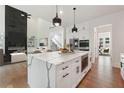 Modern kitchen features a large island, sleek white cabinets, stainless steel appliances, and hardwood flooring at 3920 Clifton Hill Court #16, Cumming, GA 30040