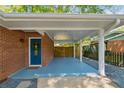 Covered carport with blue painted floor leading to the home's front door and a fenced backyard at 3700 Sexton Woods Dr, Chamblee, GA 30341