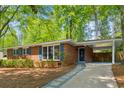 Beautiful brick home featuring a covered carport and a well-manicured lawn and walkway at 3700 Sexton Woods Dr, Chamblee, GA 30341