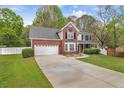 Beautiful two-story home with a well-maintained lawn, a brick facade, and a two-car garage at 404 Foxwood Ct, Mcdonough, GA 30253