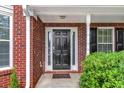 Welcoming front entrance with a classic black door framed by brick and decorative shutters at 404 Foxwood Ct, Mcdonough, GA 30253