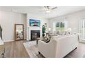 Cozy living room with fireplace, ceiling fan, stylish decor and a view to the outdoors at 3623 Squires Park Ln, Loganville, GA 30052
