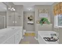 Serene bathroom featuring double sink vanity, soaking tub, and decorative wall art at 705 Sunset Ridge Se Ln, Lawrenceville, GA 30045