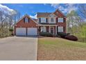 Charming two-story brick home featuring a two-car garage and a beautifully landscaped front yard at 705 Sunset Ridge Se Ln, Lawrenceville, GA 30045