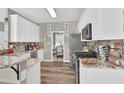 Bright kitchen boasts white cabinetry, stainless steel appliances, and granite countertops at 705 Sunset Ridge Se Ln, Lawrenceville, GA 30045