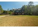 Exterior view showing a two-story home with a large front yard bordered by trees at 170 Shoal Park Dr, Mcdonough, GA 30252