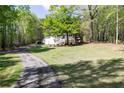 Charming home with a well-manicured front yard, mature trees, and a long driveway for ample parking at 4960 Old Yorkville Rd, Dallas, GA 30157