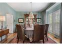 Formal dining room with beautiful blue walls, hardwood floors, and a large window for natural light at 295 Sagamore Nw Cv, Sugar Hill, GA 30518