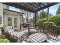 Relaxing outdoor patio with comfortable seating, a pergola, and a grill for entertaining at 295 Sagamore Nw Cv, Sugar Hill, GA 30518