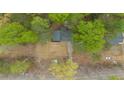 Aerial view of a home nestled among lush trees with a long driveway at 4695 Waters Rd, Woodstock, GA 30188