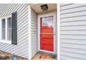 Close-up of a bright red front door with glass panels and dark shutters at 4695 Waters Rd, Woodstock, GA 30188