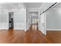 Open-concept living area featuring hardwood floors, white trim, recessed lights and a barn door at 6091 Wayfarer Dr, Villa Rica, GA 30180