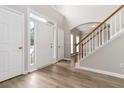 Bright entryway with hardwood floors, a staircase with white banister, and a view of the front door at 7415 Marina Cv, Stone Mountain, GA 30087