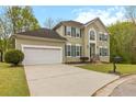 Lovely two-story home with a driveway, a two-car garage, green shutters, and manicured landscaping at 7415 Marina Cv, Stone Mountain, GA 30087