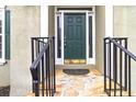 Inviting front entrance with stone steps, a sturdy black railing, and a solid green front door at 7415 Marina Cv, Stone Mountain, GA 30087