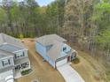 An aerial view captures a charming blue house with a gray roof and a well-kept lawn at 1037 Devon Dr, Acworth, GA 30102
